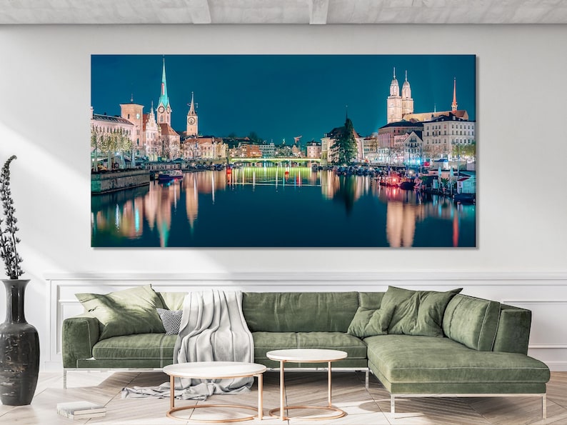 Night city skyline with illuminated buildings and tall spires reflected on a calm river