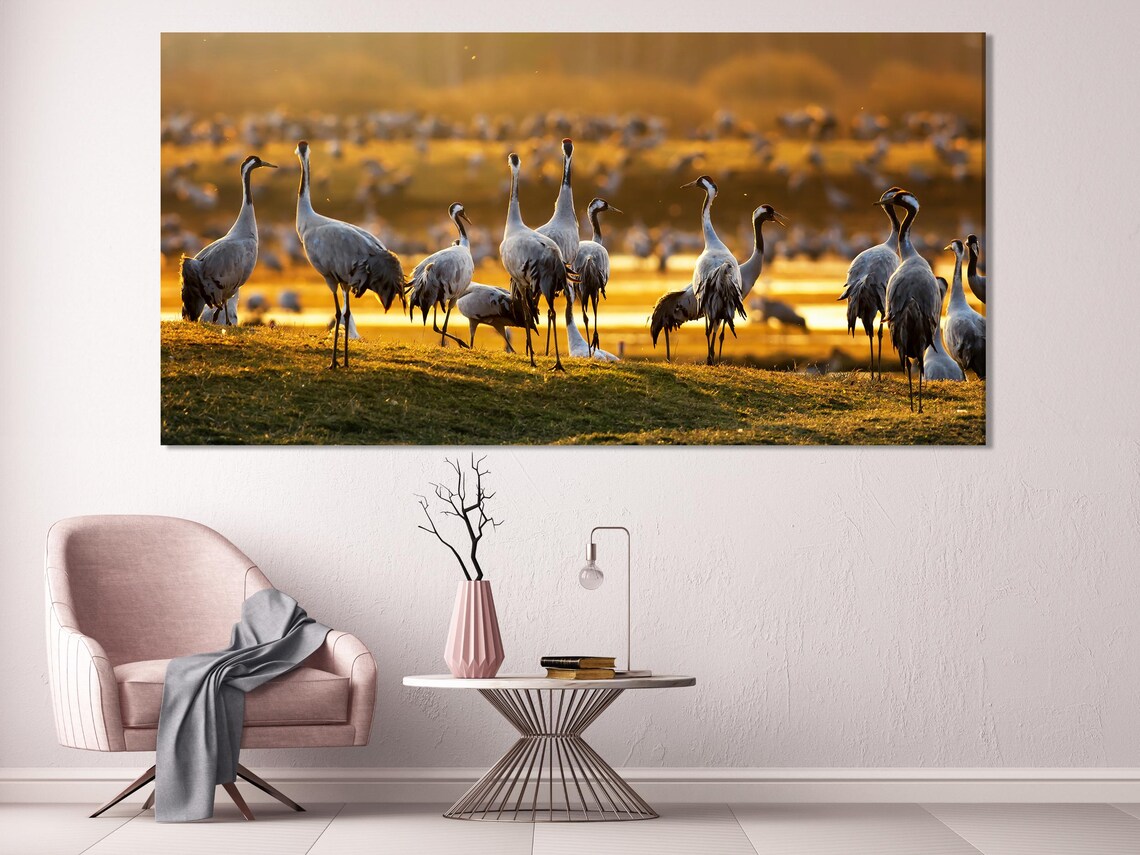 Living room mockup with a sofa and two chairs, with a five-panel crane bird wall artwork above
