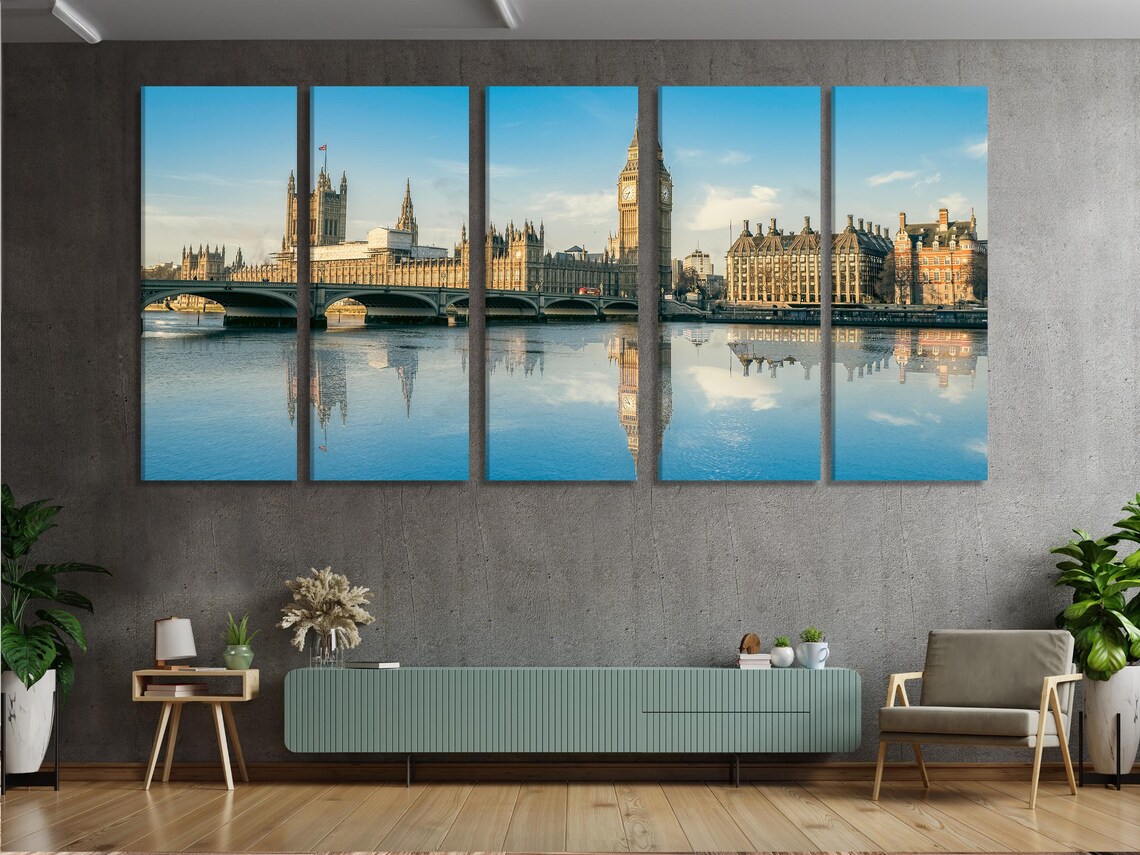 London skyline artwork featuring a tall clock tower, buildings, a bridge, and their reflections in a river under a blue sky detail view