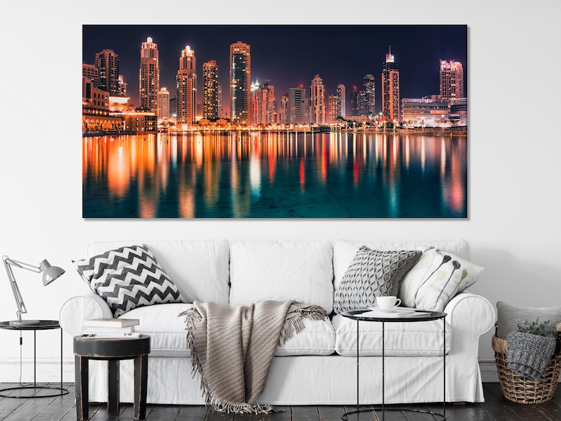 Night city skyline with illuminated skyscrapers and glowing reflections on water