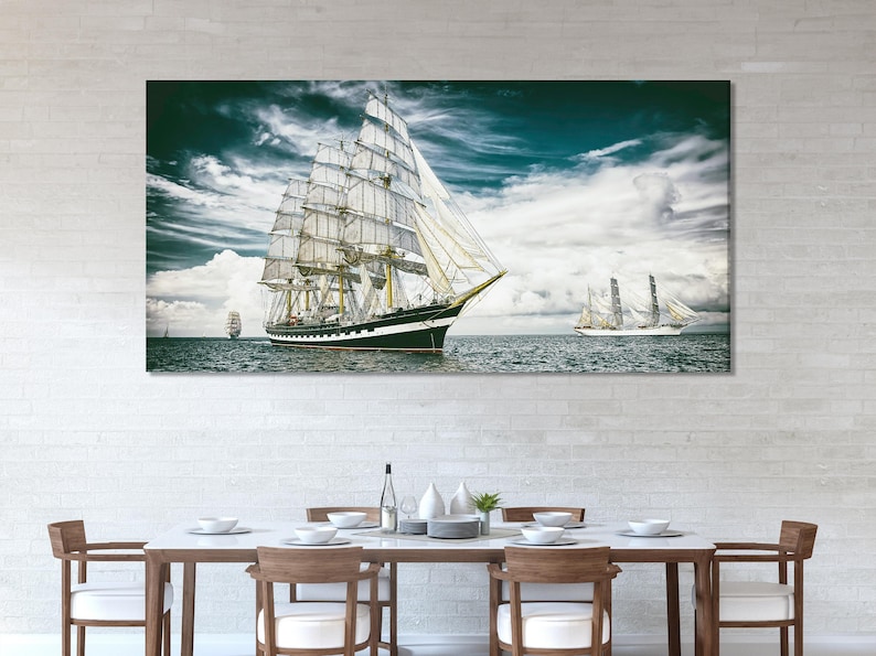 Tall sailing ship with white sails on choppy teal-green ocean under storm clouds