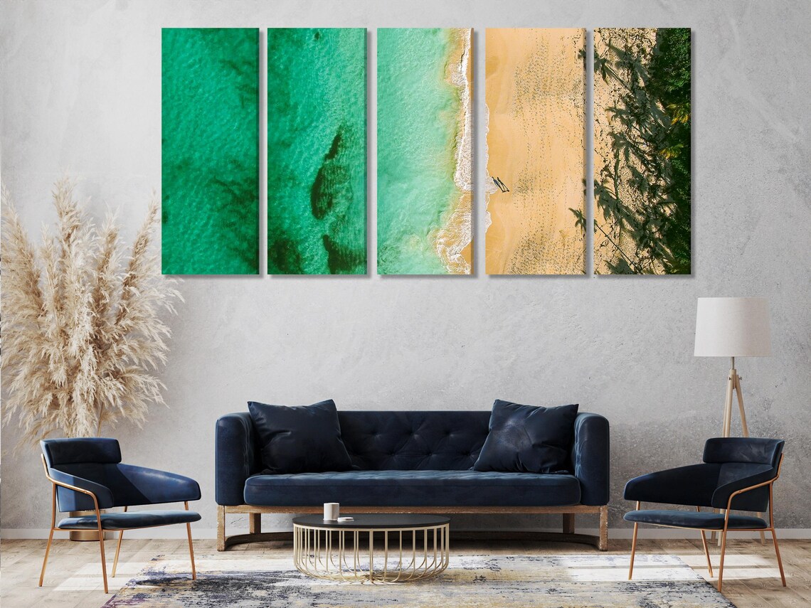 Living room scene with an ocean beach artwork above a sofa and coffee table