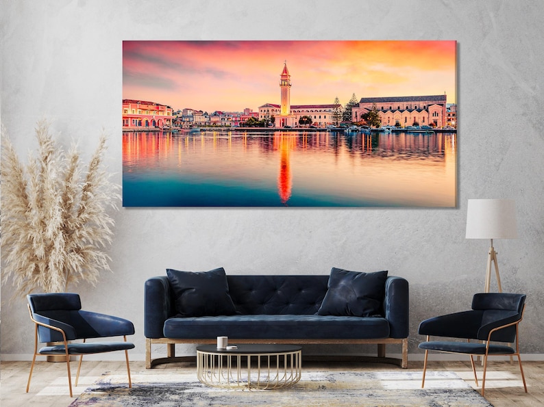 Sunset coastal town with a church tower and mirrored reflections on calm water