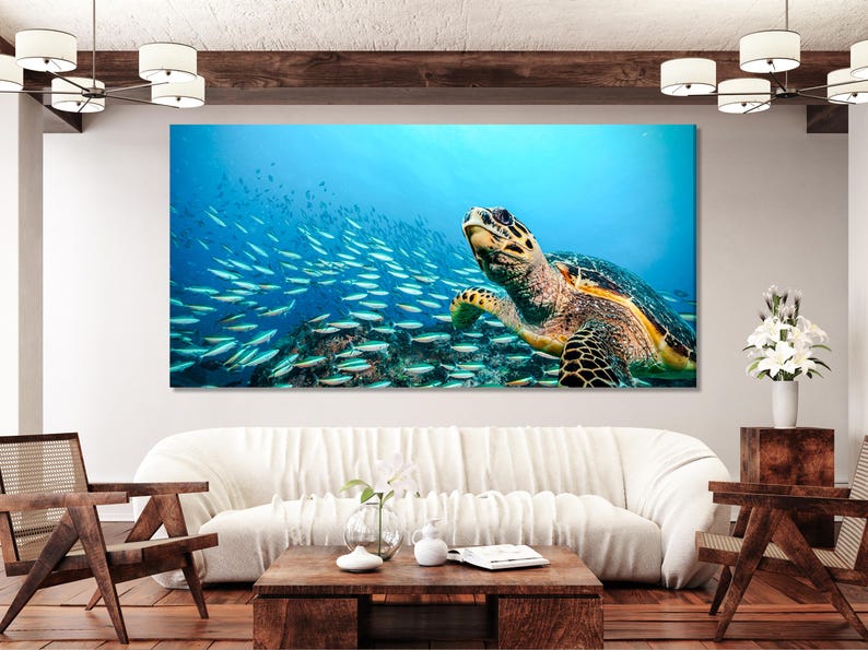 Underwater sea turtle swimming with a school of fish in blue ocean water