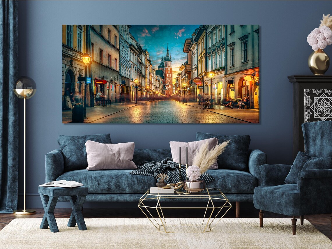 Three-panel night city street scene with glowing streetlamps and a central cathedral tower under a blue sky detail view