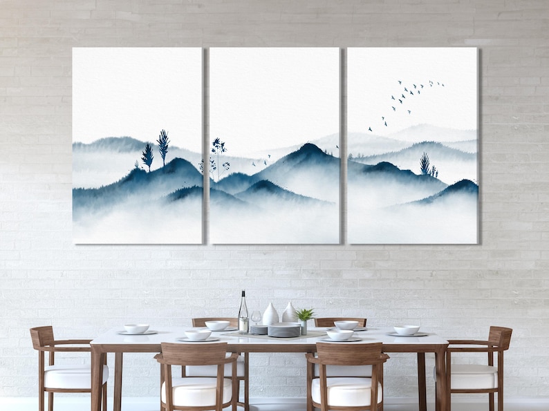 Three-panel misty blue mountain landscape with bird silhouettes and slender plant shapes