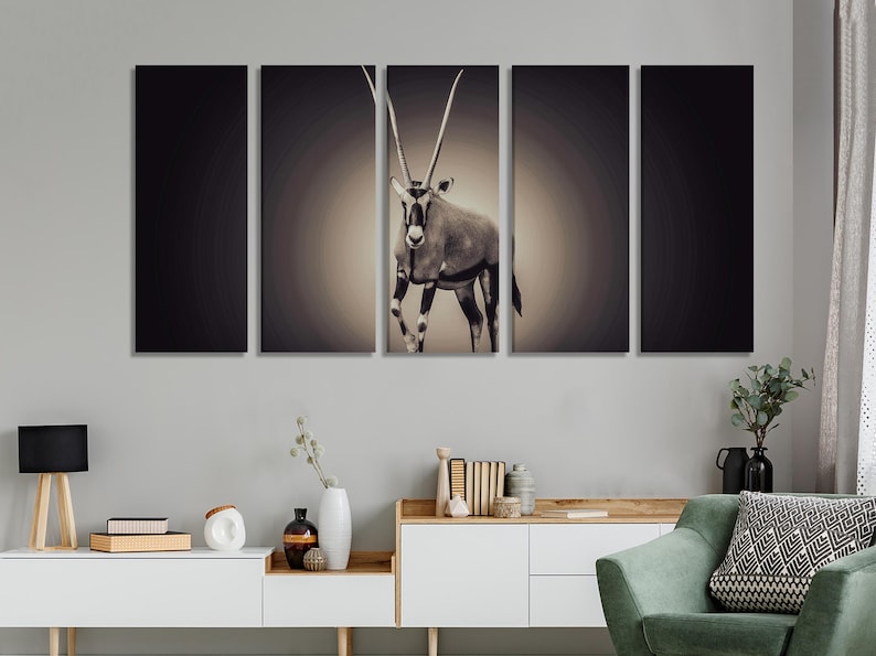 May include: A split canvas wall art print featuring a black and white image of an oryx, an antelope with long, curved horns, standing in a desert landscape.