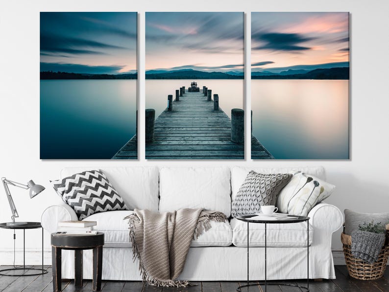 Three-panel lakeside pier over calm water with a blue and pink sunset sky reflection