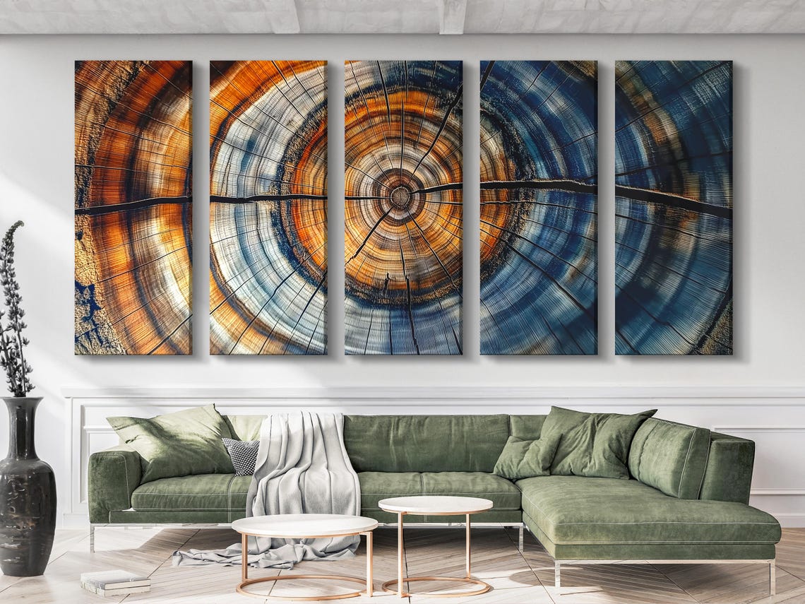 Dining table in a room with three blue and burnt orange abstract tree-ring panels on the wall