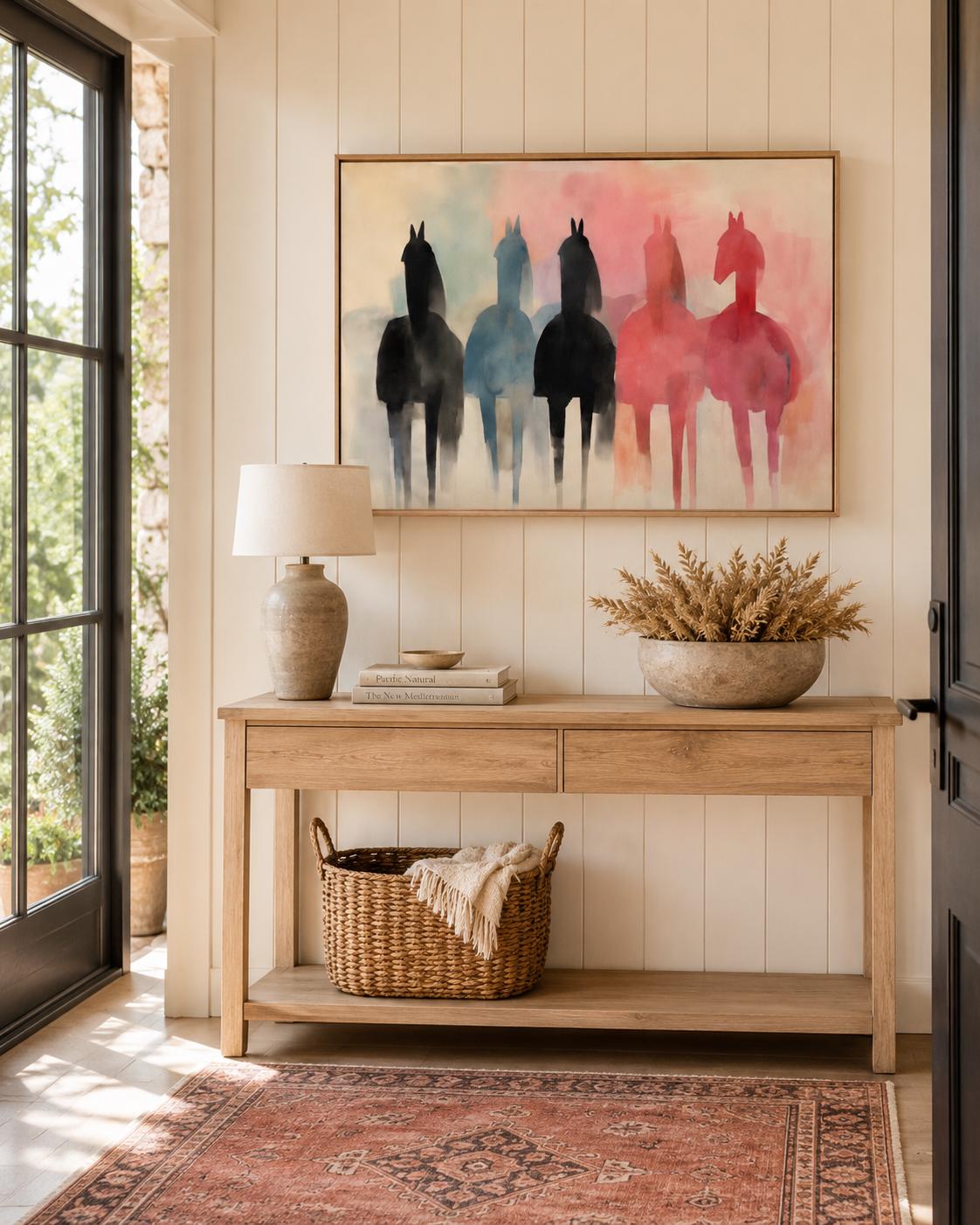 A person standing near a floor plant and a framed horse silhouette artwork on a wall