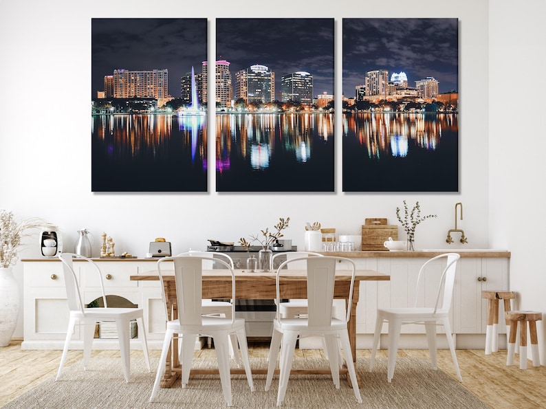Three-panel night cityscape with illuminated buildings and reflections on dark lake water
