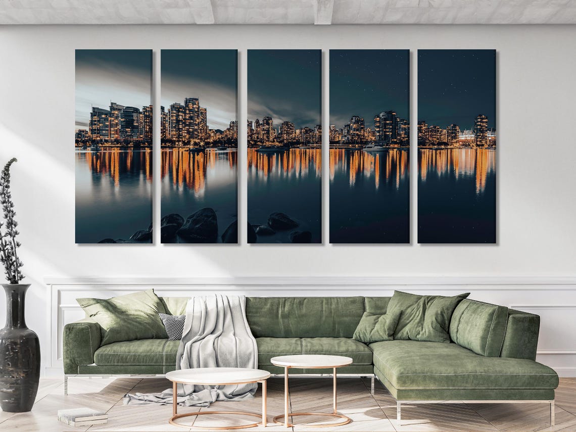 Night city skyline with warm building lights reflected on calm dark water detail view