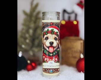 Puede incluir: Una vela blanca con un diseño festivo que presenta un perro con un gorro de Papá Noel y un suéter rojo. La vela tiene un borde dorado y el texto "All I want for Christmas is more" está impreso en la etiqueta.
