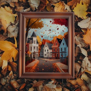 K&ouml;nnte beinhalten: Ein gerahmtes Kunstwerk mit Herbstthema, das eine Stra&szlig;e mit bunten H&auml;usern zeigt. Die H&auml;user sind in Wei&szlig;, Rot und Blau gehalten, mit B&auml;umen in leuchtenden Herbstfarben. Das Kunstwerk ist vor einem Hintergrund aus fallenden Bl&auml;ttern mit einem braunen Rahmen.