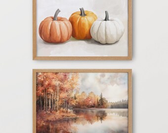 May include: Two framed prints, one with a watercolor painting of three pumpkins, one orange, one white, and one peach, and the other with a watercolor painting of a lake with trees in the fall.