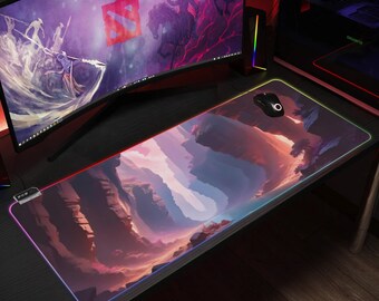 May include: A rectangular gaming mouse mat featuring a landscape design in shades of purple, pink, and orange. The mat has a glowing LED edge with a black mouse on top. A computer monitor and tower are in the background.