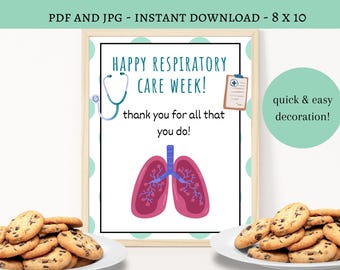 May include: A framed print with the text "HAPPY RESPIRATORY CARE WEEK!" and a stethoscope illustration. The image also includes a drawing of lungs and the words "thank you for all that you do!" Two plates of chocolate chip cookies are in the foreground.