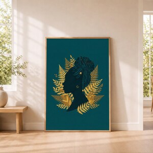 Könnte beinhalten: Ein gerahmter Wandkunstdruck mit dunkelblaugrünem Hintergrund und der Silhouette einer Person im Profil. Die Person trägt geflochtenes Haar in einem hohen Dutt, verziert mit goldenen Akzenten. Goldene Farnblätter umgeben die Figur.
