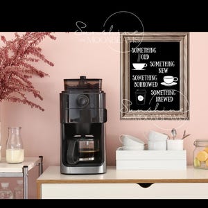 May include: A black coffee maker with a glass carafe sits on a white countertop next to a framed chalkboard sign that reads "Something Old, Something New, Something Borrowed, Something Brewed".