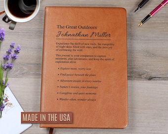 May include: A brown leather journal with the text "The Great Outdoors" and "Johnathan Miller" printed on the cover. The journal includes inspirational text about exploration. The words "MADE IN THE USA" are printed on a brown rectangle.