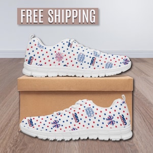 May include: White sneakers with a patriotic pattern of red and blue stars, bows, and fireworks. The shoes are displayed on a brown box. The text "FREE SHIPPING" is above the shoes.