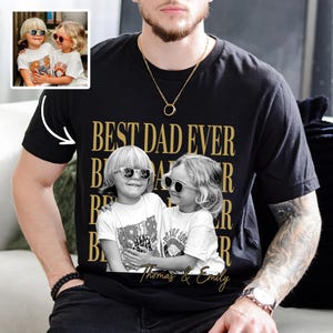 May include: Black t-shirt with a gold "BEST DAD EVER" design and a black and white photo of two children wearing sunglasses. The children's names, "Thomas & Emily," are printed below the photo.