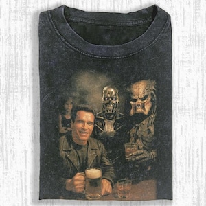 Könnte beinhalten: Schwarzes T-Shirt mit einem Vintage-Grafik von Arnold Schwarzenegger, einem Terminator und einem Predator in einer Bar. Das Bild hat einen Used-Look. Die Charaktere halten Getränke. Rundhalsausschnitt.