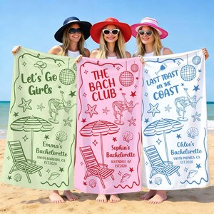 Peut inclure: Trois serviettes de plage aux couleurs pastel, chacune avec des motifs et du texte uniques. Les serviettes présentent des illustrations sur le thème de la plage, notamment des sirènes, des boules disco et des chaises longues. Le texte comprend "Let's Go Girls", "The Bach Club" et "Last Toast on the Coast."