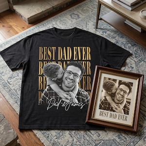 K&ouml;nnte beinhalten: Schwarzes T-Shirt mit goldenem Text "BEST DAD EVER" und einem Sepia-Foto eines Mannes und eines Kindes. Ein gerahmtes Foto mit dem gleichen Bild und Text ist ebenfalls vorhanden.