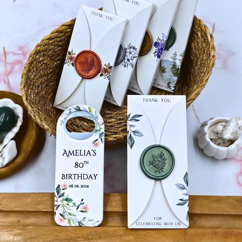 May include: A set of white thank you cards with a green floral design and a wax seal. The cards are folded in half and have a thank you message on the front. The cards are perfect for a birthday party or other special occasion.