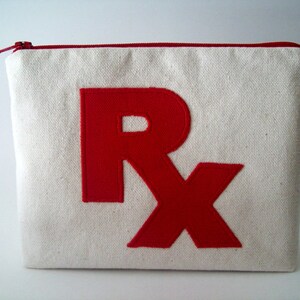 May include: A white canvas zippered pouch with a red felt "Rx" design.