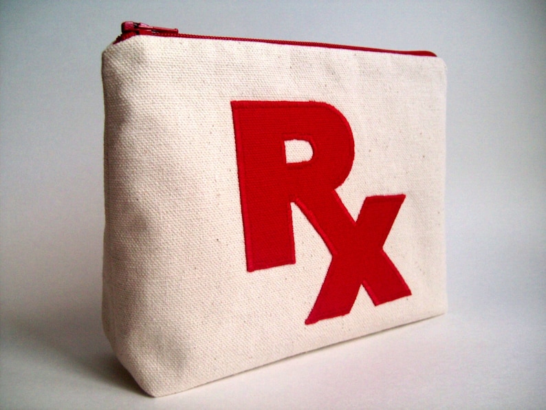 May include: A white canvas zippered pouch with a large red embroidered "RX" on the front.