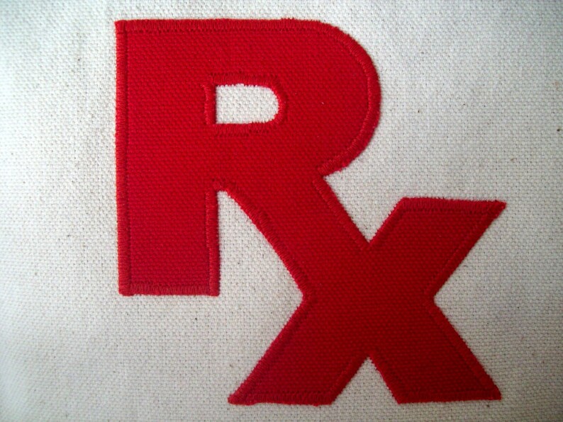 May include: Red fabric letters "RX" sewn onto a white canvas background.