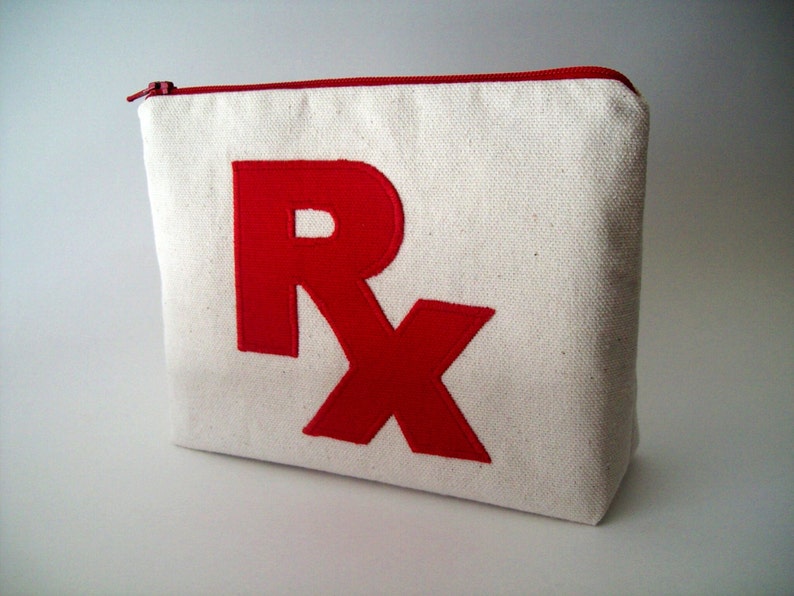 May include: A white canvas zippered pouch with a red embroidered "Rx" on the front.