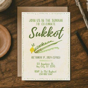 May include: An invitation card with the text "JOIN US IN THE SUKKAH TO CELEBRATE Sukkot" in green. The card includes the date "OCTOBER 17, 2024" and an RSVP contact. The card is on a wooden surface with decorative elements.