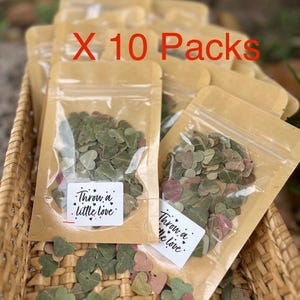 May include: Ten packs of heart-shaped confetti in clear pouches with brown paper tops. The confetti is a mix of green and pink hues. Each pouch has a sticker that reads "Throw a little love."