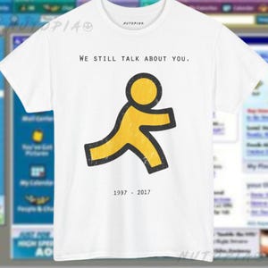 May include: A white short-sleeve t-shirt featuring a yellow running figure icon with a black outline. Above the figure is the text WE STILL TALK ABOUT YOU. Below the figure is the text 1997 - 2017. The shirt has a crew neckline and a Nutopia logo.