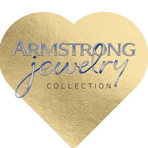 May include: A gold heart-shaped logo with the text "ARMSTRONG jewelry COLLECTION" in blue script. The heart has a textured, metallic appearance, and the text is in a stylized font, suggesting a jewelry brand.