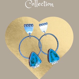 May include: A pair of silver earrings from the Armstrong Jewelry Collection. Each earring features a large silver hoop, a triangular turquoise stone, and a silver top with small silver beads. The background is a gold heart shape.