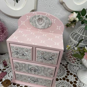 Handcrafted wooden dresser-style jewelry and craft organizer with pink and gray tones, decorated with hand-painted roses, featuring a textured surface and acrylic lacquer finish — perfect as a gift for mom, sister, or daughter.