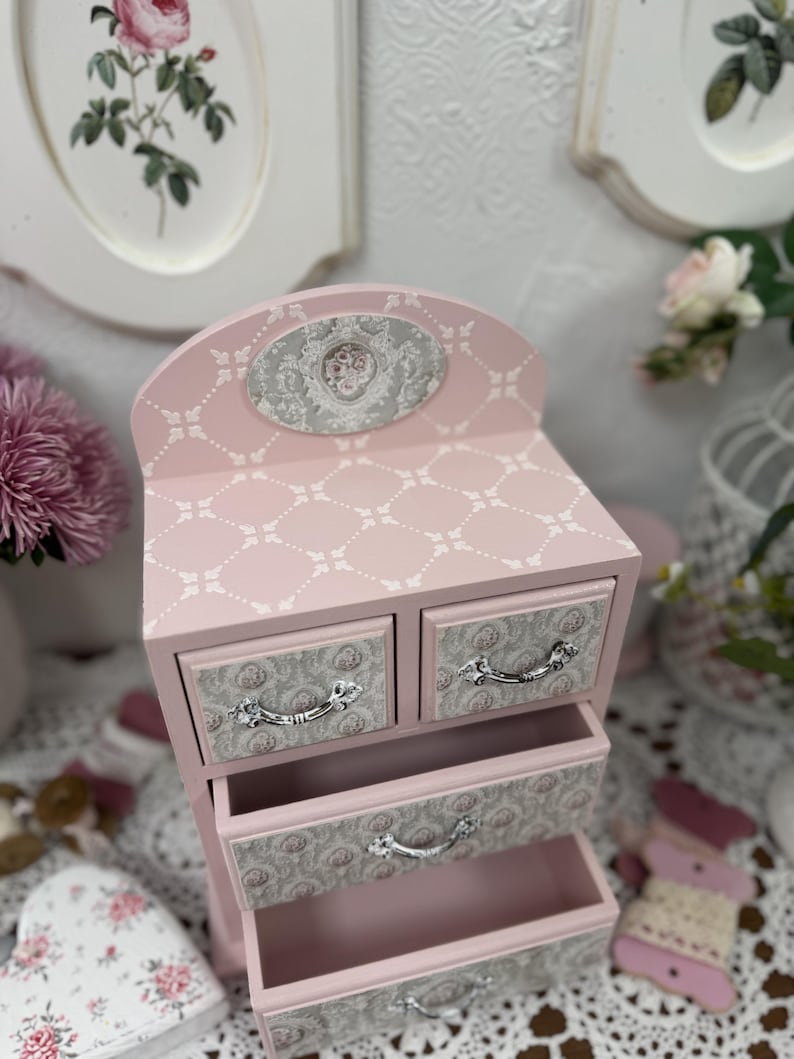 Handcrafted wooden dresser-style jewelry and craft organizer with pink and gray tones, decorated with hand-painted roses, featuring a textured surface and acrylic lacquer finish — perfect as a gift for mom, sister, or daughter.