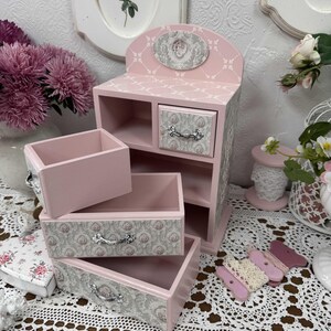 Handcrafted wooden dresser-style jewelry and craft organizer with pink and gray tones, decorated with hand-painted roses, featuring a textured surface and acrylic lacquer finish — perfect as a gift for mom, sister, or daughter.