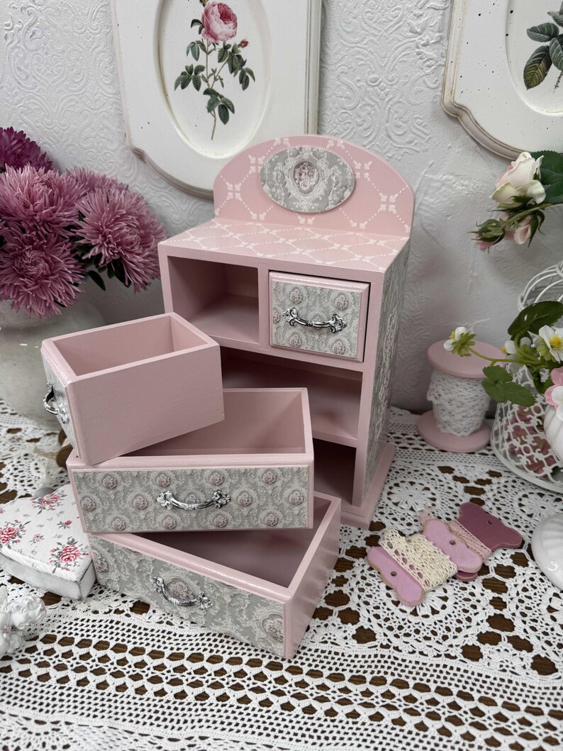 Handcrafted wooden dresser-style jewelry and craft organizer with pink and gray tones, decorated with hand-painted roses, featuring a textured surface and acrylic lacquer finish — perfect as a gift for mom, sister, or daughter.