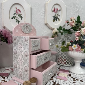 Handcrafted wooden dresser-style jewelry and craft organizer with pink and gray tones, decorated with hand-painted roses, featuring a textured surface and acrylic lacquer finish — perfect as a gift for mom, sister, or daughter.