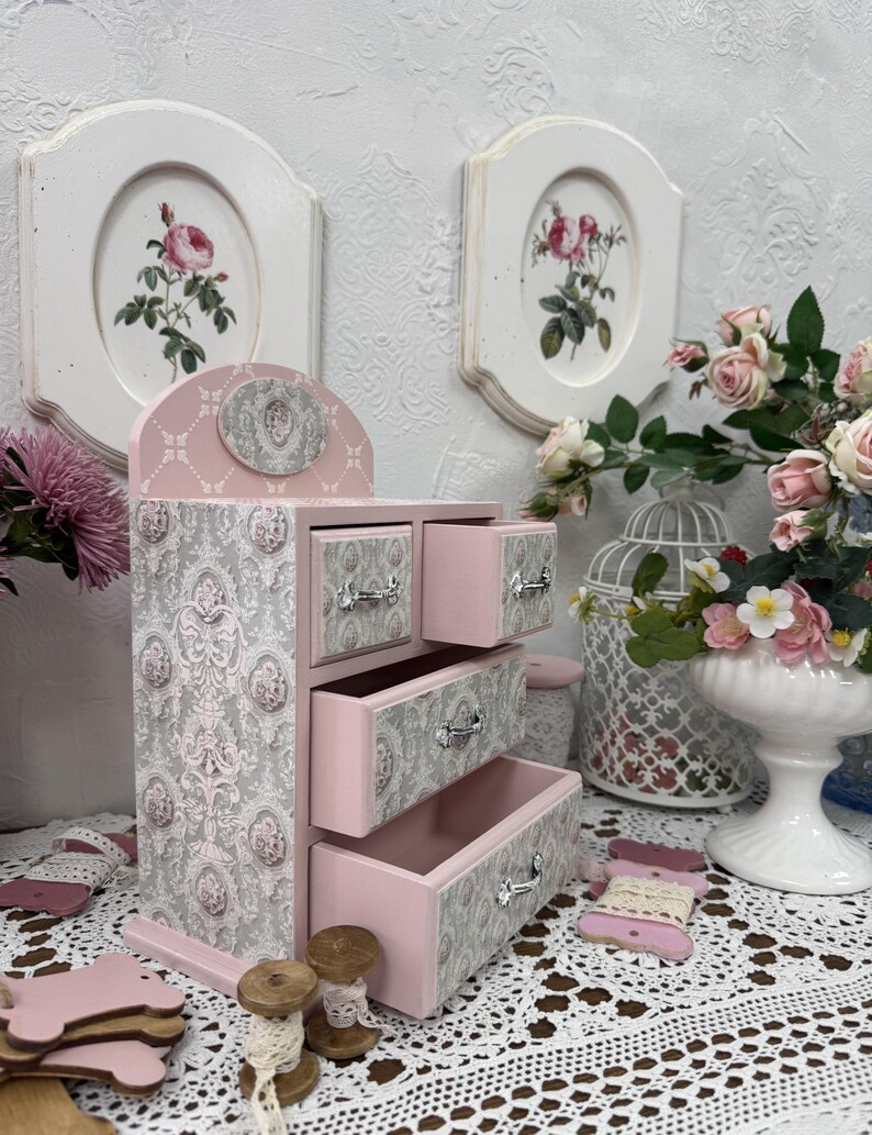 Handcrafted wooden dresser-style jewelry and craft organizer with pink and gray tones, decorated with hand-painted roses, featuring a textured surface and acrylic lacquer finish — perfect as a gift for mom, sister, or daughter.
