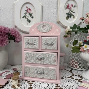 Handcrafted wooden dresser-style jewelry and craft organizer with pink and gray tones, decorated with hand-painted roses, featuring a textured surface and acrylic lacquer finish — perfect as a gift for mom, sister, or daughter.