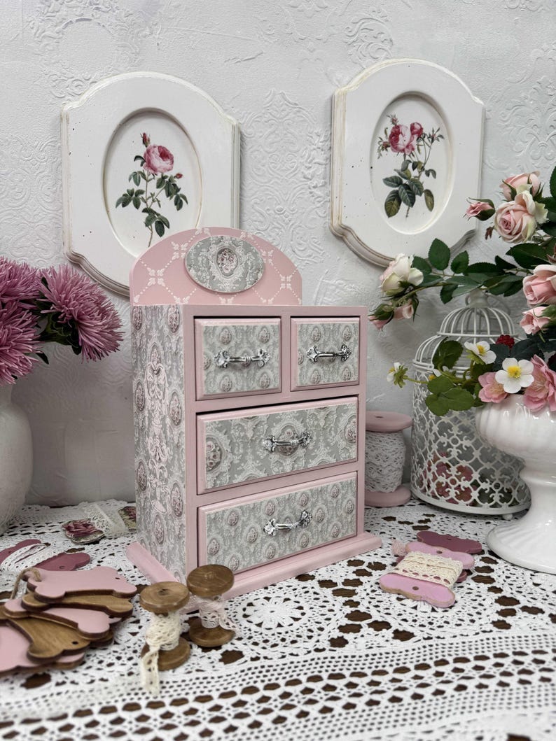Handcrafted wooden dresser-style jewelry and craft organizer with pink and gray tones, decorated with hand-painted roses, featuring a textured surface and acrylic lacquer finish — perfect as a gift for mom, sister, or daughter.