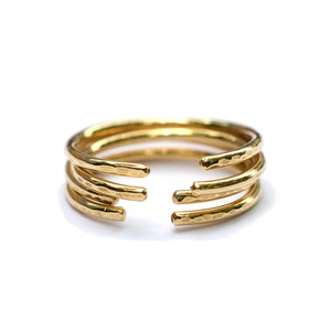 May include: Gold ring with four bands, each with a hammered texture. The bands are open at the top, creating a unique design.