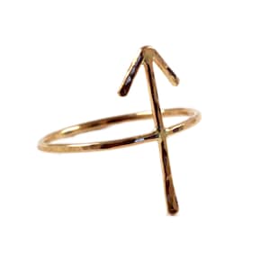 May include: Gold-toned ring with a hammered finish and a Sagittarius zodiac symbol.