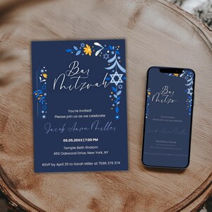 Op de afbeelding: Een marineblauwe Bar Mitzvah-uitnodiging en een smartphone met hetzelfde ontwerp. De uitnodiging heeft bloemen- en Davidster-accenten in blauw en geel. De tekst bevat evenementdetails en RSVP-informatie.